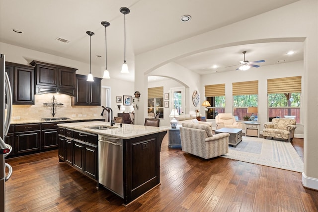 kitchen featuring stainless steel appliances, dark wood-type flooring, sink, pendant lighting, and an island with sink