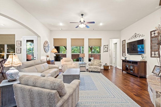 living room with ceiling fan and dark wood-type flooring