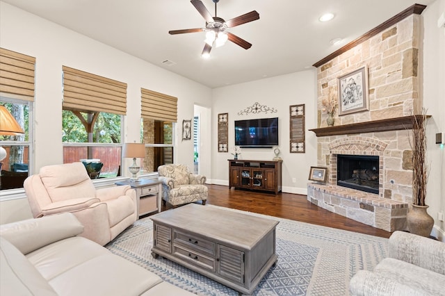 living room featuring hardwood / wood-style flooring, ceiling fan, and a fireplace