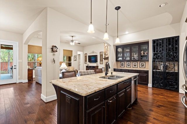 kitchen featuring an island with sink, ceiling fan, dark wood-type flooring, and sink