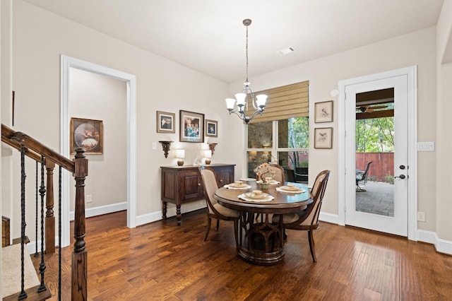 dining space featuring dark wood-type flooring and an inviting chandelier