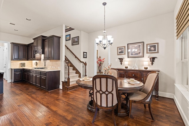 dining room with dark hardwood / wood-style floors, an inviting chandelier, and sink