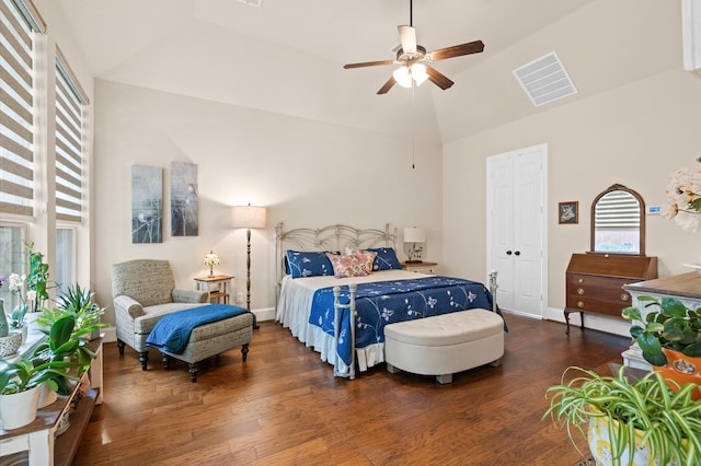 bedroom featuring dark hardwood / wood-style floors, ceiling fan, high vaulted ceiling, and a closet