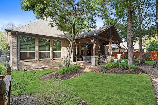 back of house featuring central AC, a yard, an outdoor kitchen, and a patio area