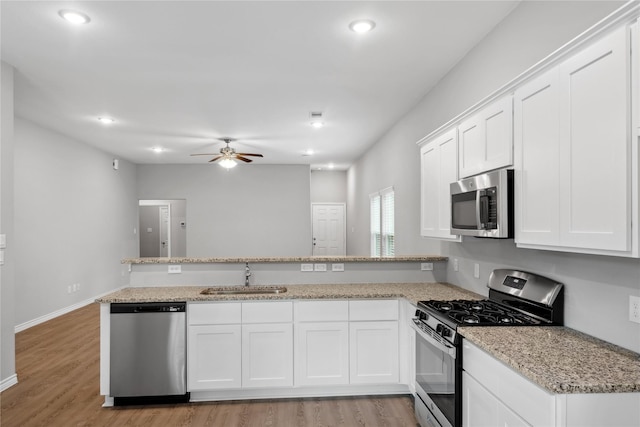 kitchen featuring white cabinets, light wood-type flooring, stainless steel appliances, and sink