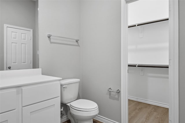 bathroom featuring vanity, hardwood / wood-style flooring, and toilet