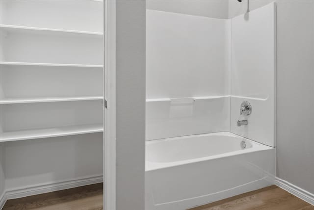 bathroom featuring hardwood / wood-style floors and bathing tub / shower combination