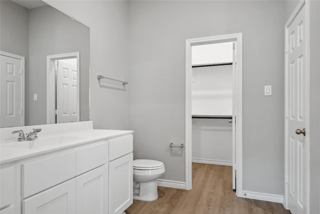 bathroom with vanity, toilet, and wood-type flooring