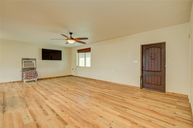 unfurnished living room featuring ceiling fan, a wall unit AC, and light wood-type flooring