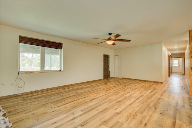 spare room with ceiling fan and light wood-type flooring