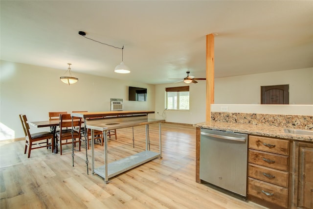 kitchen featuring pendant lighting, dishwasher, light hardwood / wood-style floors, and light stone countertops