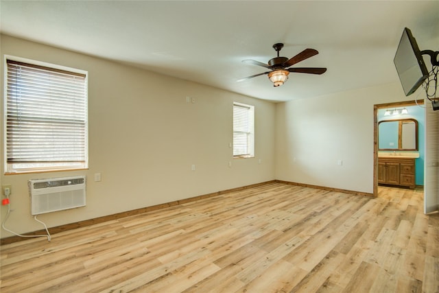 empty room featuring ceiling fan, a wall unit AC, and light hardwood / wood-style flooring