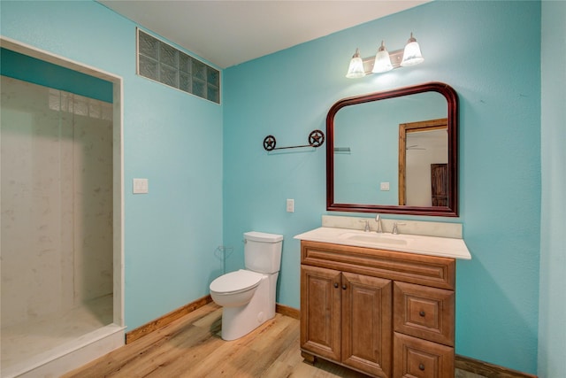 bathroom featuring wood-type flooring, toilet, vanity, and a shower