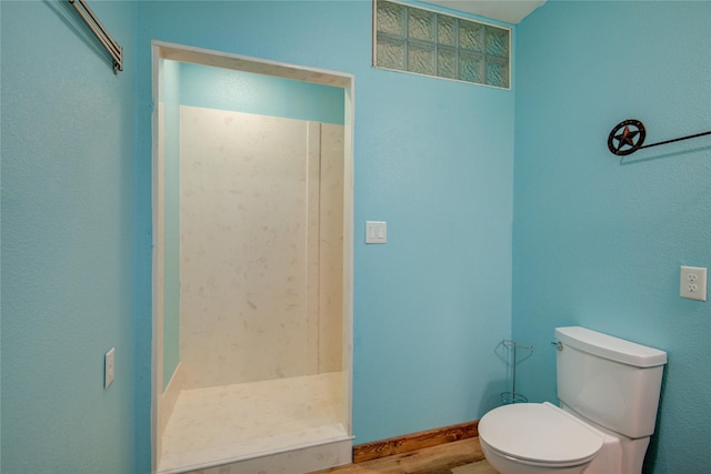 bathroom featuring hardwood / wood-style floors, a shower, and toilet