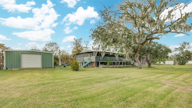 view of yard featuring a garage, a sunroom, and an outbuilding