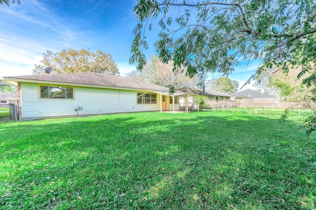 rear view of house featuring a lawn