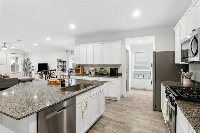 kitchen featuring white cabinets, sink, appliances with stainless steel finishes, and light hardwood / wood-style flooring