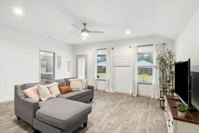 living room featuring ceiling fan, light hardwood / wood-style floors, and vaulted ceiling