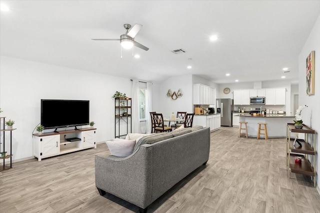 living room featuring ceiling fan and light wood-type flooring