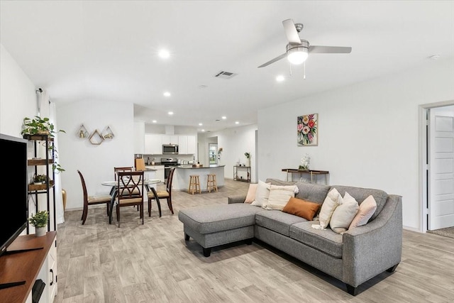 living room featuring light hardwood / wood-style floors and ceiling fan