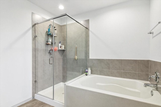 bathroom with plus walk in shower and hardwood / wood-style flooring