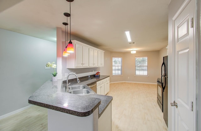 kitchen featuring kitchen peninsula, light wood-type flooring, sink, pendant lighting, and white cabinetry