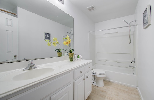 full bathroom featuring washtub / shower combination, vanity, wood-type flooring, and toilet