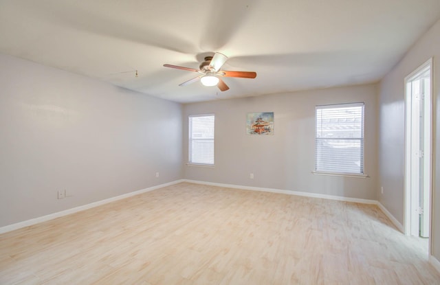 empty room featuring light hardwood / wood-style floors, a wealth of natural light, and ceiling fan