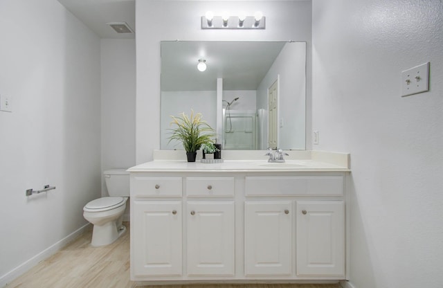 bathroom with a shower, vanity, wood-type flooring, and toilet