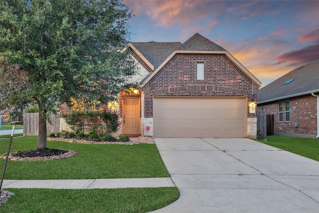 front of property with a garage and a lawn