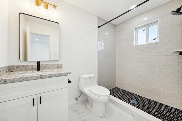 bathroom featuring vanity, toilet, and a tile shower