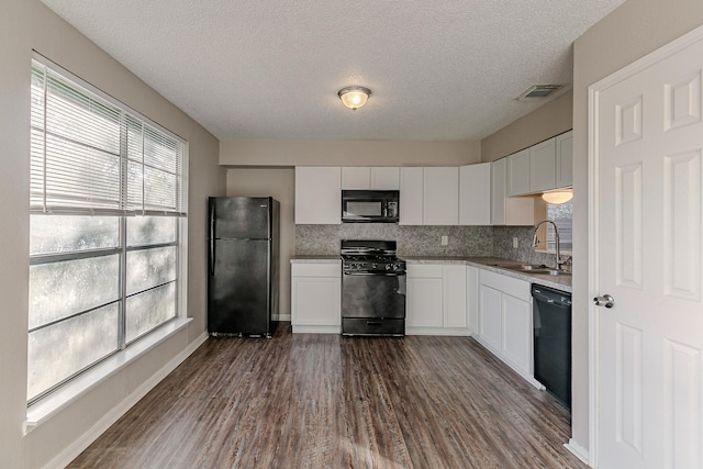 kitchen featuring a textured ceiling, dark wood-type flooring, sink, black appliances, and white cabinets