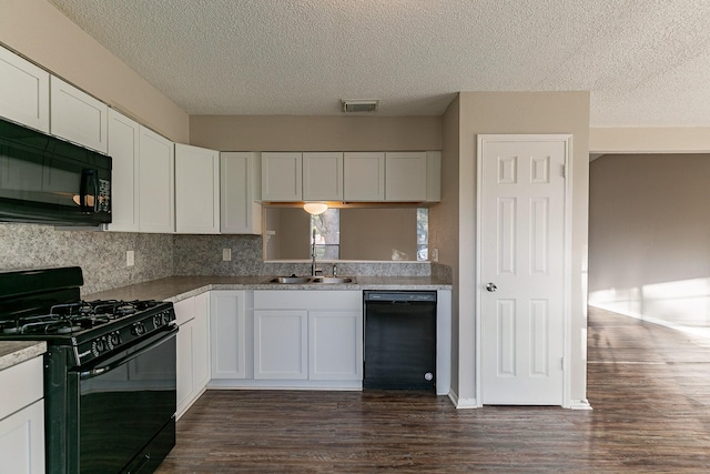 kitchen with sink, dark hardwood / wood-style floors, white cabinetry, and black appliances