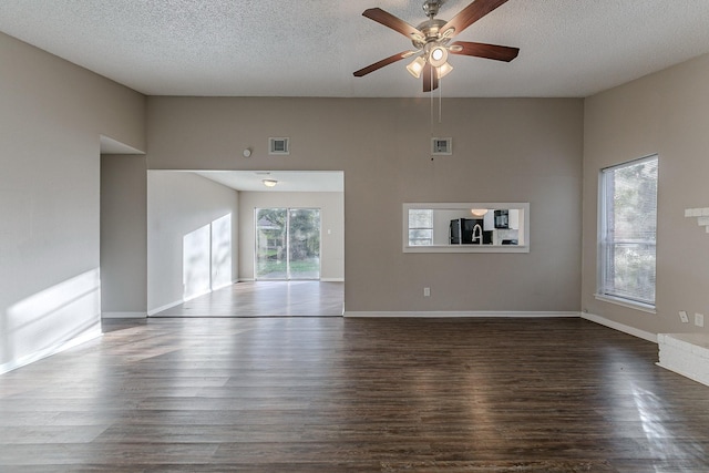 unfurnished living room featuring a textured ceiling, dark hardwood / wood-style flooring, and ceiling fan