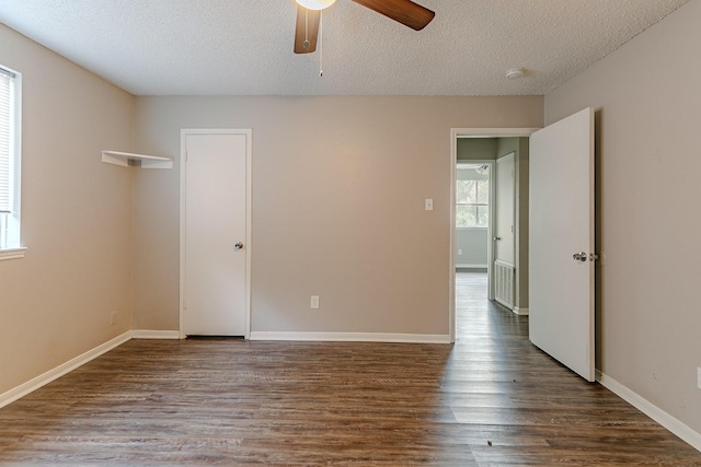 unfurnished room featuring ceiling fan, dark wood-type flooring, and a textured ceiling