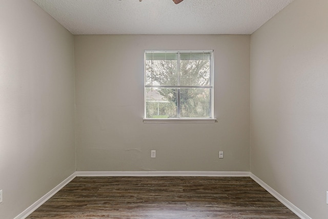 empty room with a textured ceiling, ceiling fan, and dark hardwood / wood-style floors