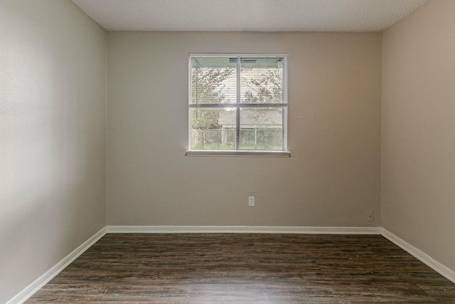 unfurnished room with dark wood-type flooring and a textured ceiling