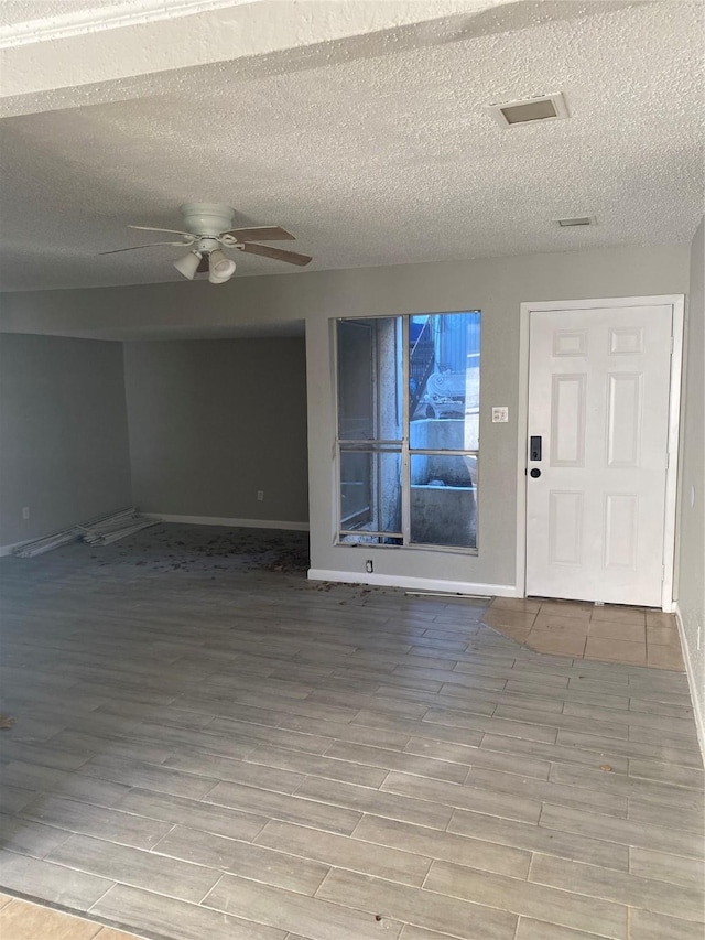 entrance foyer featuring ceiling fan and a textured ceiling