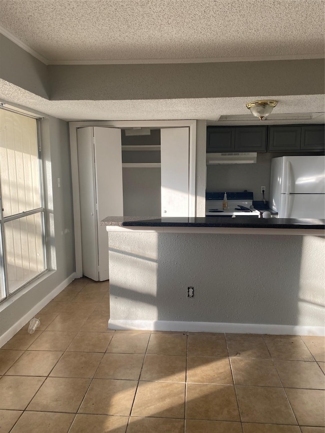 kitchen with range, tile patterned flooring, a textured ceiling, and white refrigerator