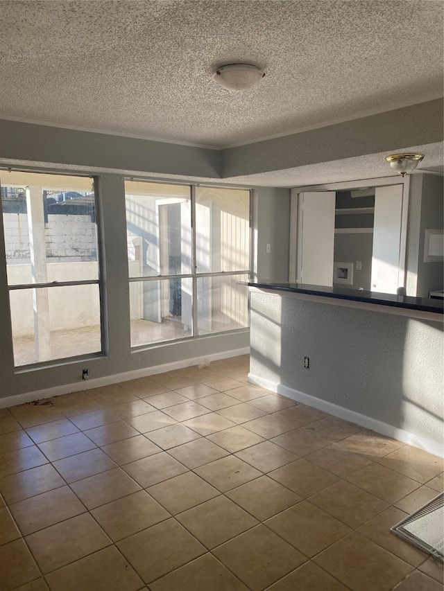 spare room featuring tile patterned flooring and a textured ceiling