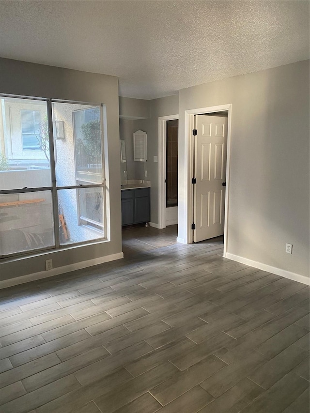 empty room with dark hardwood / wood-style flooring and a textured ceiling