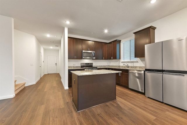 kitchen with hardwood / wood-style floors, a center island, dark brown cabinetry, and stainless steel appliances