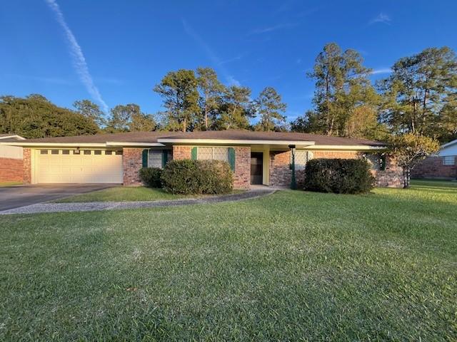 ranch-style house with a garage and a front lawn