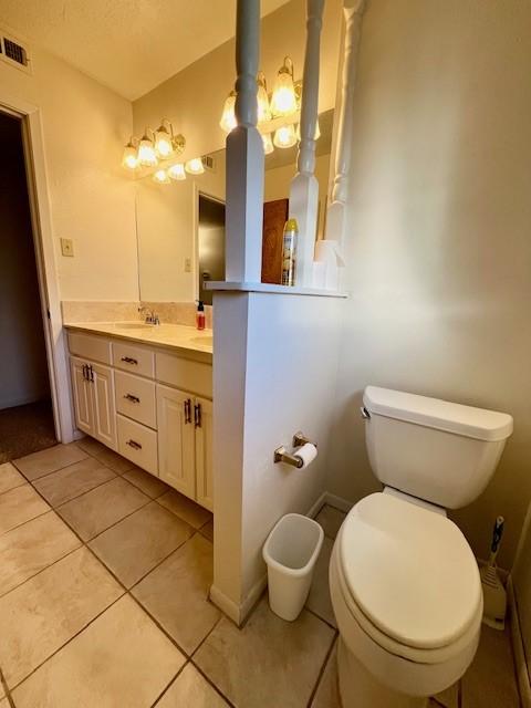 bathroom with tile patterned flooring, vanity, and toilet