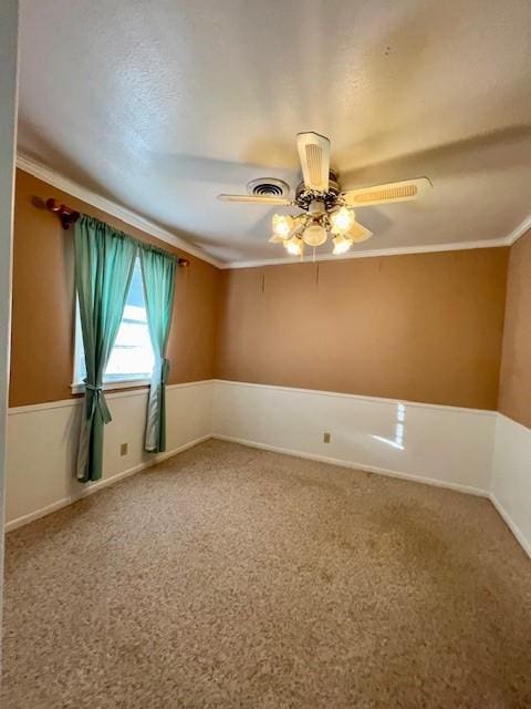 carpeted empty room with ceiling fan and crown molding