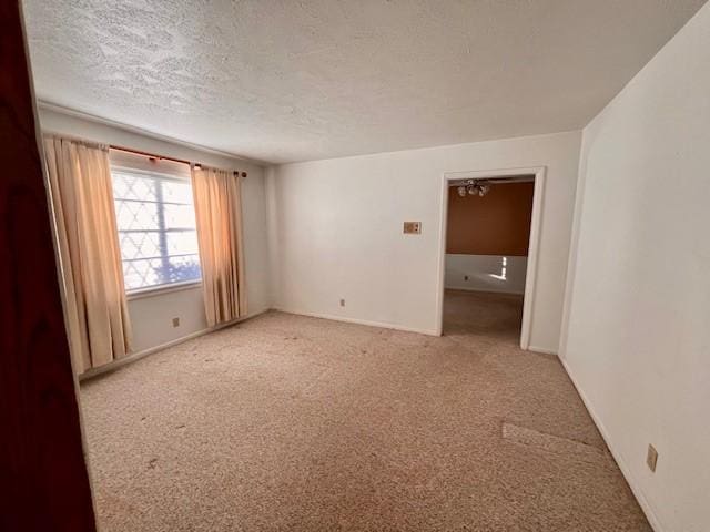 carpeted spare room with a textured ceiling