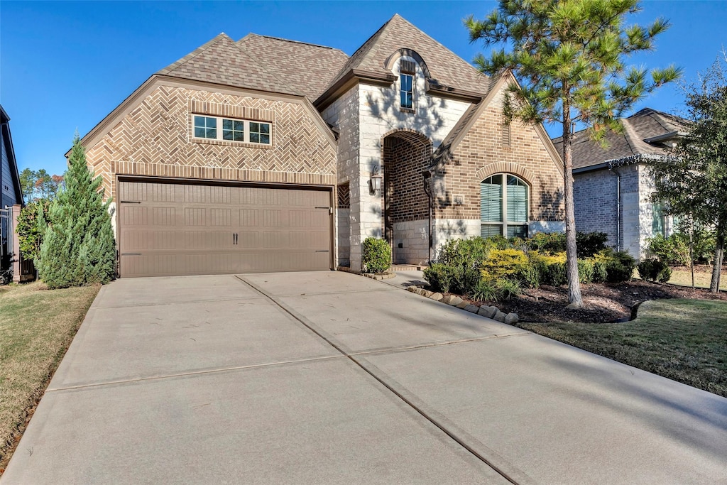 view of front of home featuring a garage and a front lawn