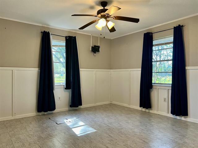 unfurnished room featuring ceiling fan, ornamental molding, and a wealth of natural light