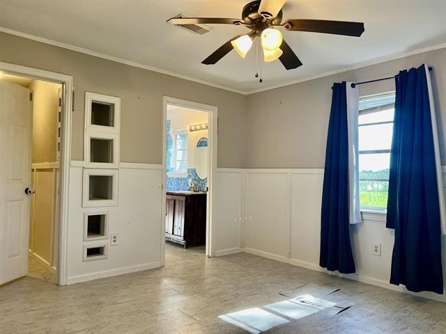 empty room with ceiling fan, ornamental molding, and light wood-type flooring