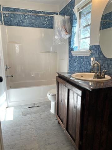 full bathroom featuring tasteful backsplash, vanity, shower / bathtub combination, and toilet